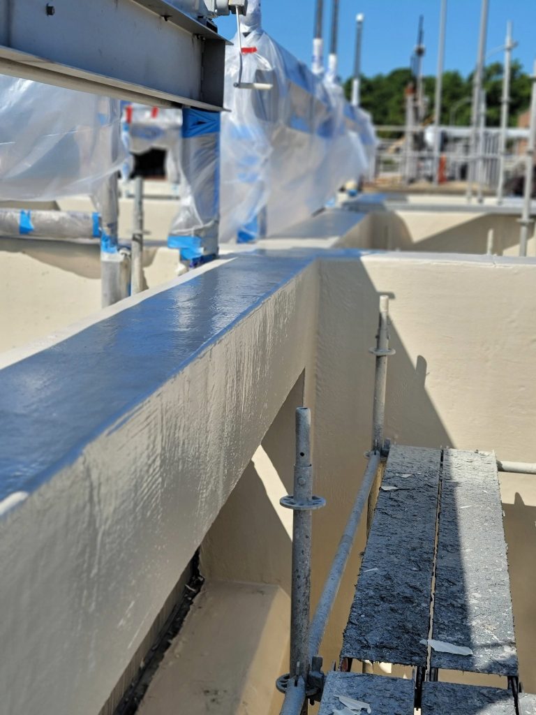 A newly coated concrete chamber is shown at an outdoor treatment facility.
