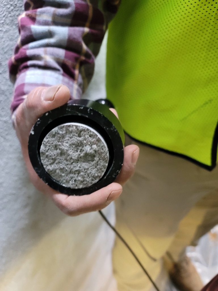 An adhesion pull-off test showing concrete substrate failure, indicating the protective coating achieved a bond strength greater than the concrete itself.